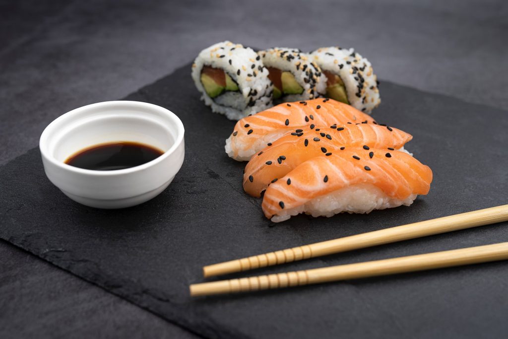 sushi on black plate with chopsticks