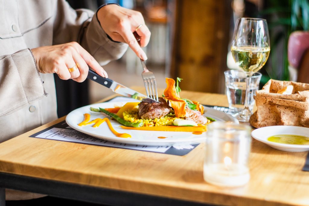 person cutting into a steak