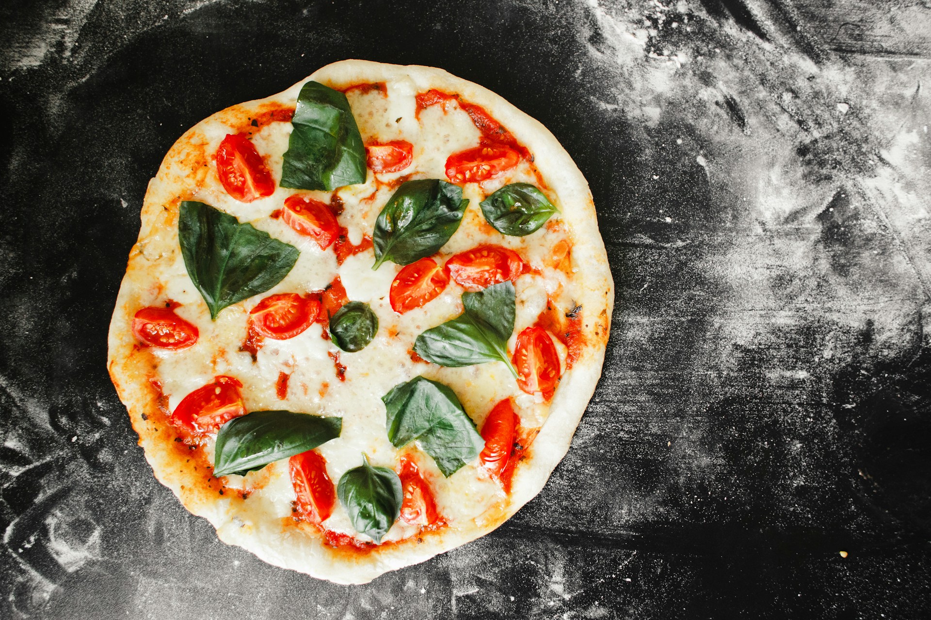 Pizza with spinach leaves and tomato